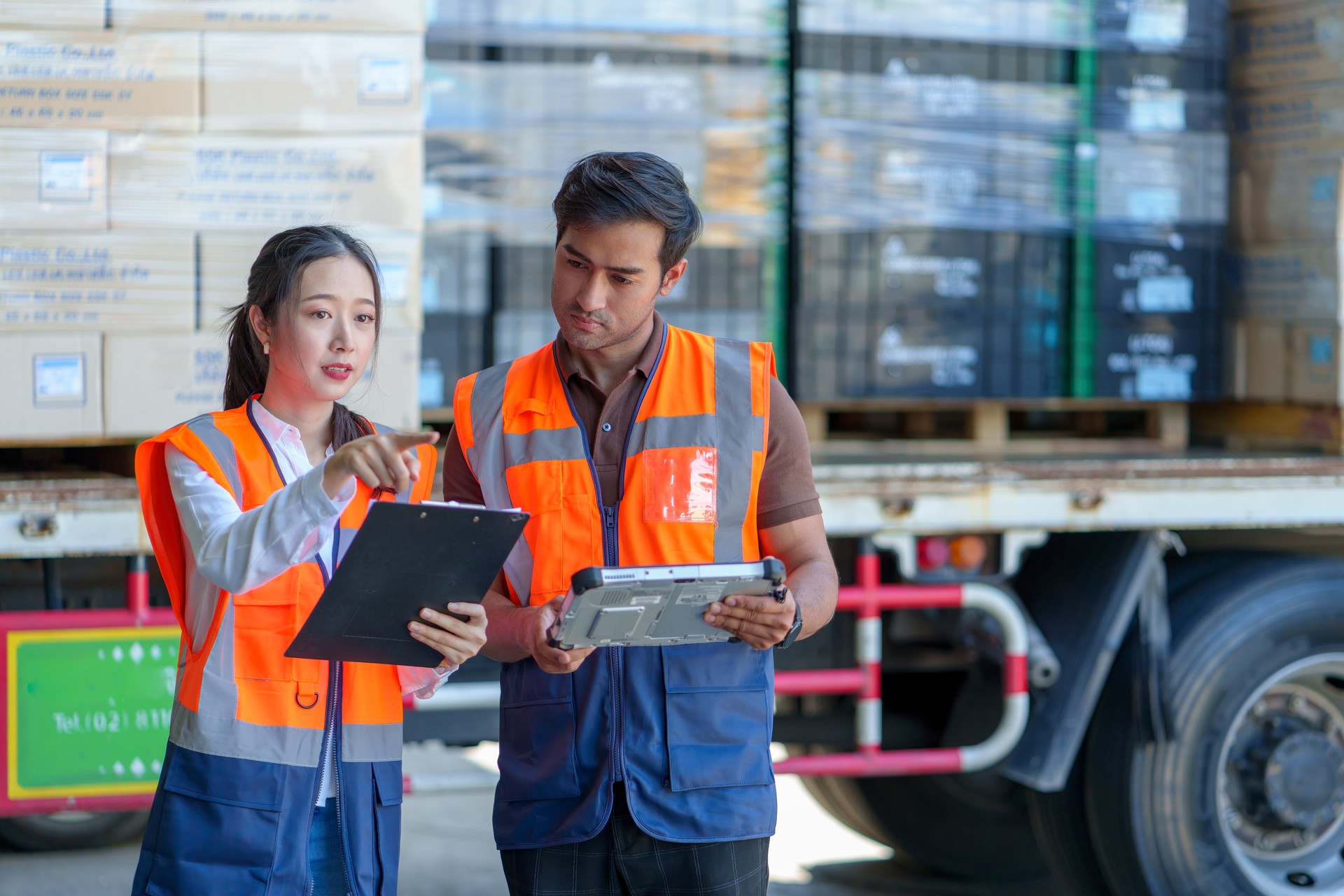 Warehouse workers discussing shipping schedule at Loading and unloading a lorry.